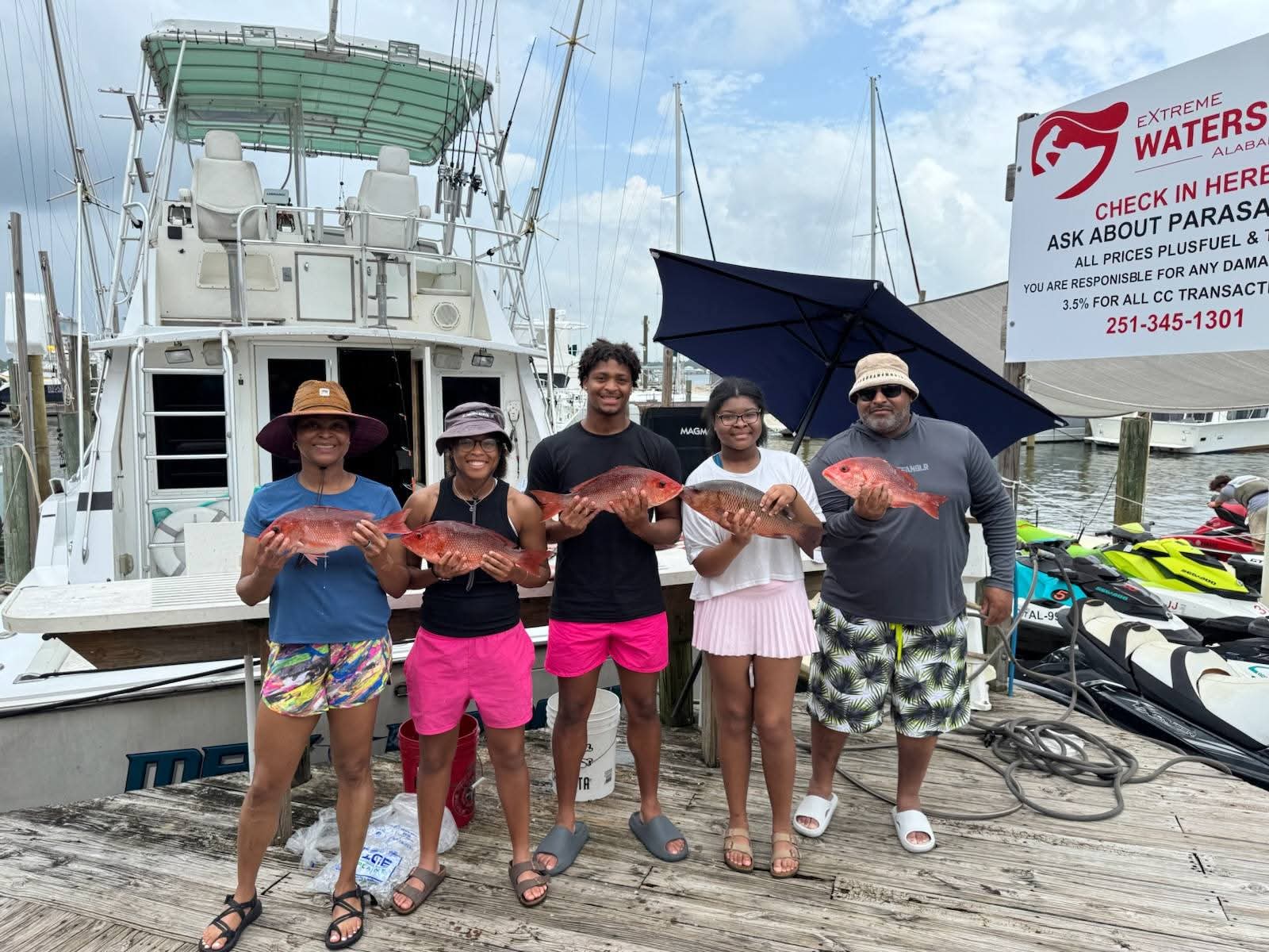 Family with red snapper at the marina